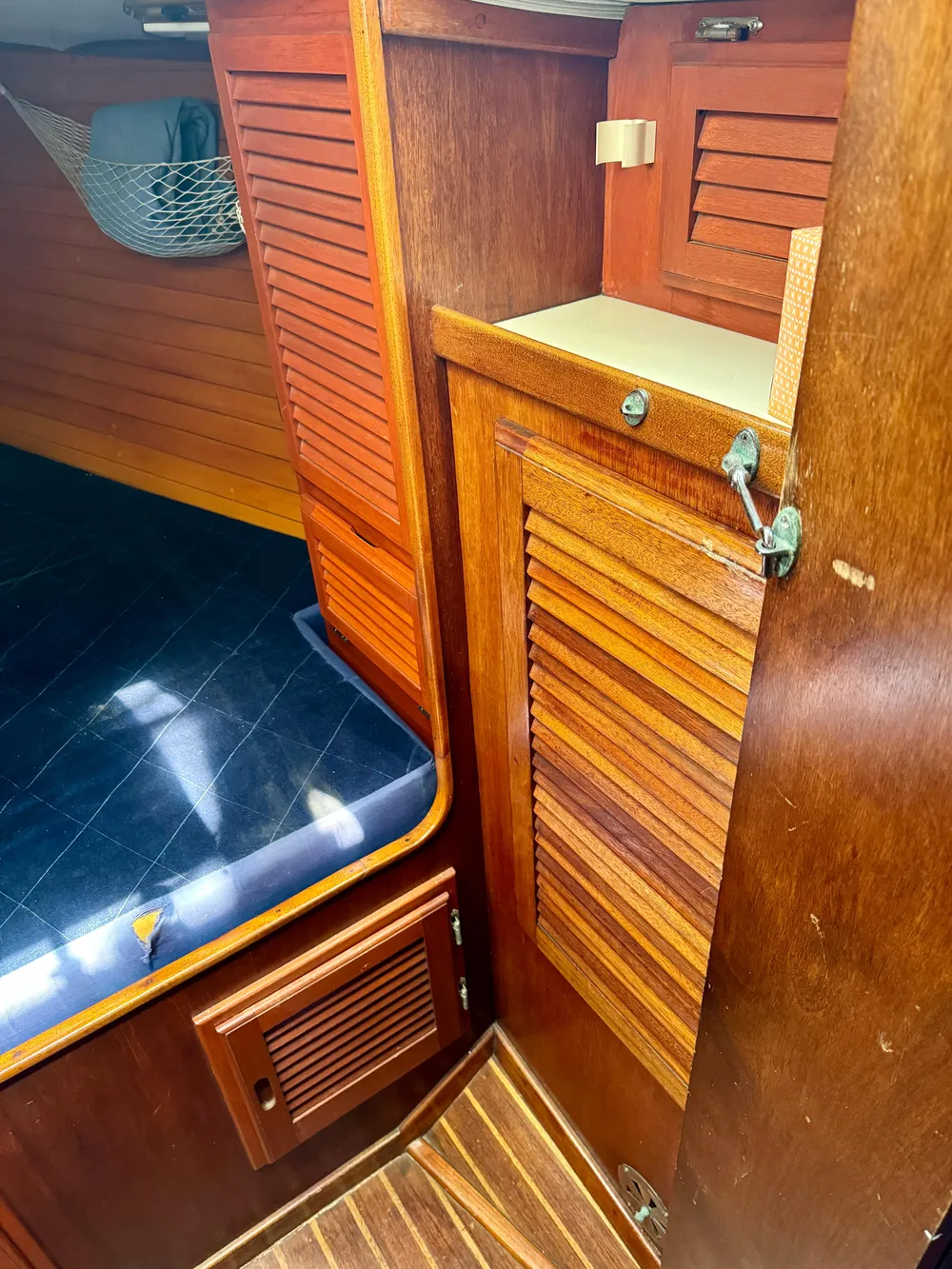 1979 Islander IP Peterson 40 interior with wooden cabinetry and blue cushioned seating.