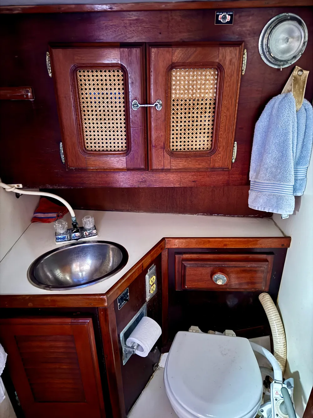 1979 Islander IP Peterson 40 yacht bathroom with wooden cabinets and stainless steel sink.