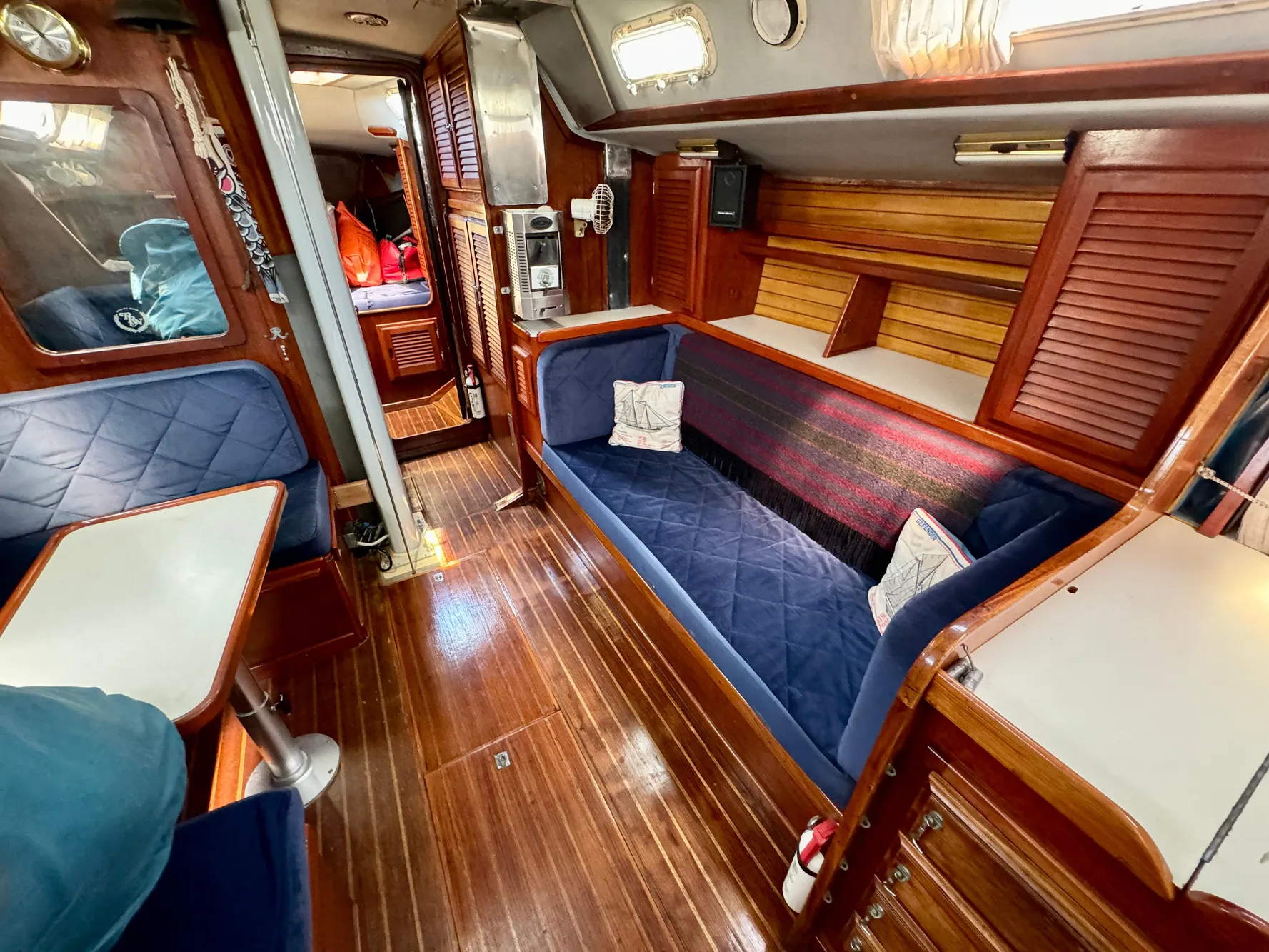 Interior of 1979 Islander IP Peterson 40 sailboat with wooden finishes and blue seating.