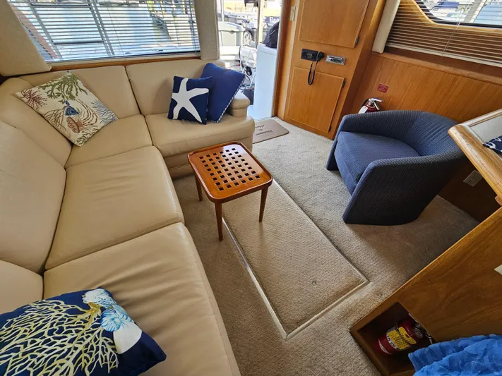  Yacht Photos Pics Interior of 1995 Hatteras 39 Sportfish with beige sofa, blue chair, and decorative pillows.