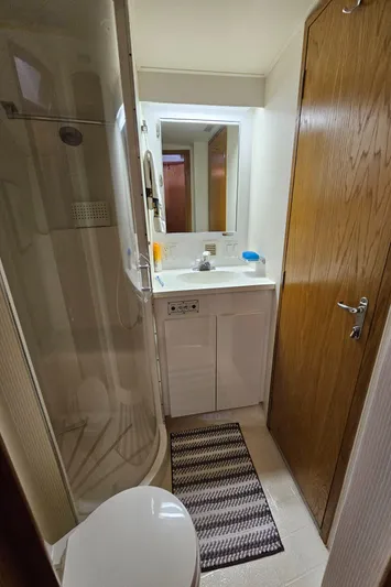  Yacht Photos Pics Bathroom interior of 1995 Hatteras 39 Sportfish yacht with shower, sink, and wooden door.