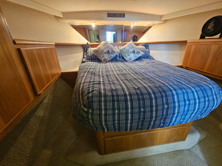  Yacht Photos Pics Cozy cabin interior of 1995 Hatteras 39 Sportfish with plaid bedding and wooden accents.