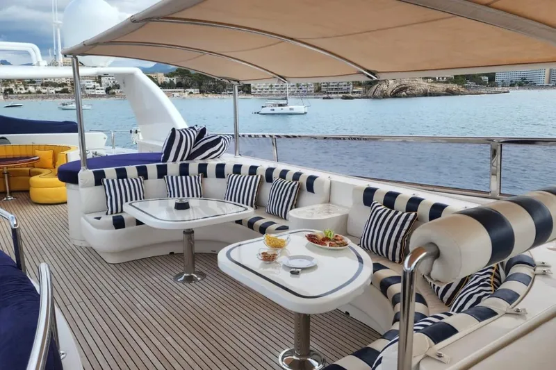  Yacht Photos Pics Luxurious Horizon 105 yacht deck with striped seating, tables, and ocean view, 2002 model.