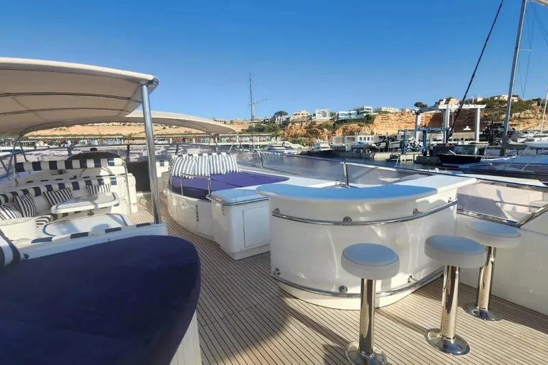  Yacht Photos Pics Luxurious Horizon 105 yacht deck with seating and bar, 2002 model, docked in scenic marina.