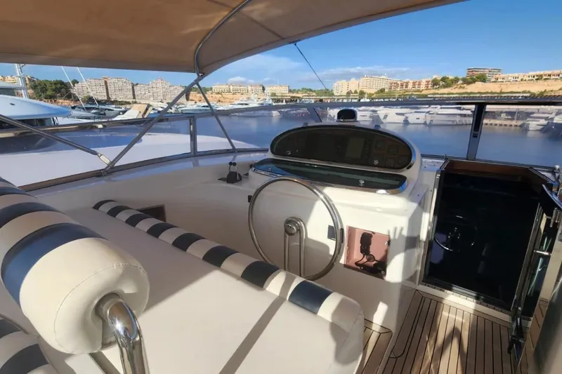  Yacht Photos Pics Luxurious Horizon 105 yacht helm, 2002 model, with striped seating and marina view.