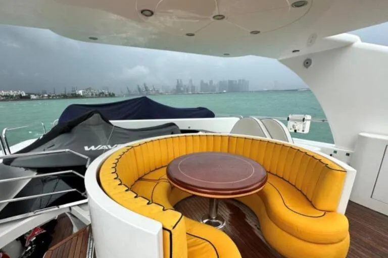  Yacht Photos Pics Luxurious 2002 Horizon 105 yacht with yellow seating, wooden table, and ocean view.