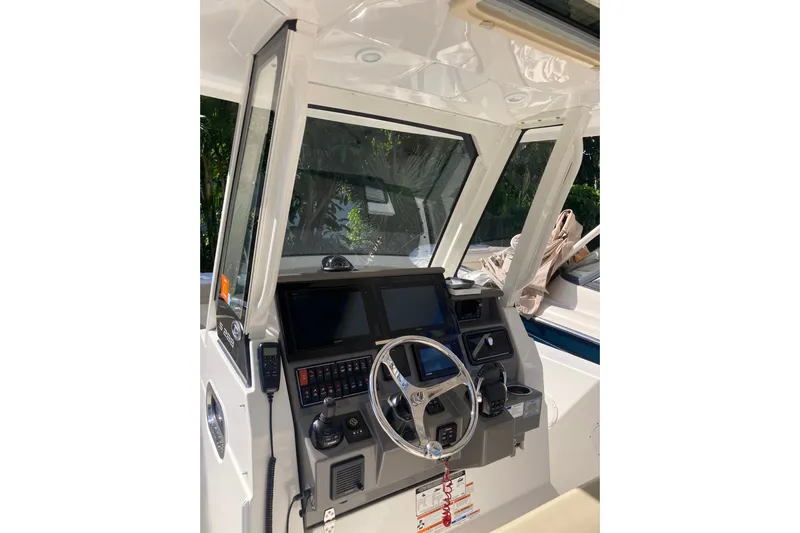 No Jet Lag Yacht Photos Pics 2019 Pursuit S 288 Sport boat dashboard with steering wheel and navigation controls.