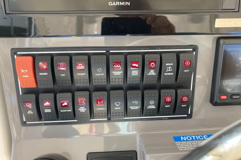 No Jet Lag Yacht Photos Pics Control panel of a 2019 Pursuit S 288 Sport boat with labeled switches.