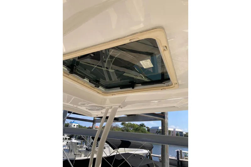 No Jet Lag Yacht Photos Pics 2019 Pursuit S 288 Sport boat with open sunroof, docked near water.