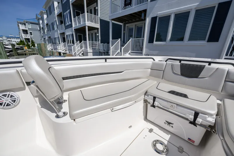 Jokers Jewel Yacht Photos Pics 2019 Wellcraft 352 Fisherman boat interior with seating and cooler, docked near modern buildings.
