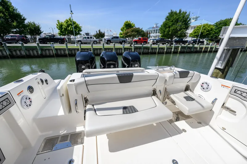 Jokers Jewel Yacht Photos Pics 2019 Wellcraft 352 Fisherman boat with seating and triple outboard motors docked by the water.