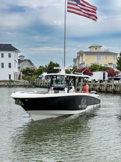 Jokers Jewel Yacht Photos Pics 2019 Wellcraft 352 Fisherman boat on water near dock, American flag in background.