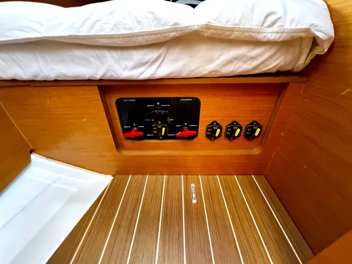  Yacht Photos Pics Electrical panel on 2011 Jeanneau Sun Odyssey 409 yacht, featuring wooden interior and striped flooring.