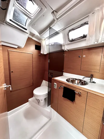  Yacht Photos Pics Luxurious bathroom in 2011 Jeanneau Sun Odyssey 409 yacht with modern fixtures and wood accents.