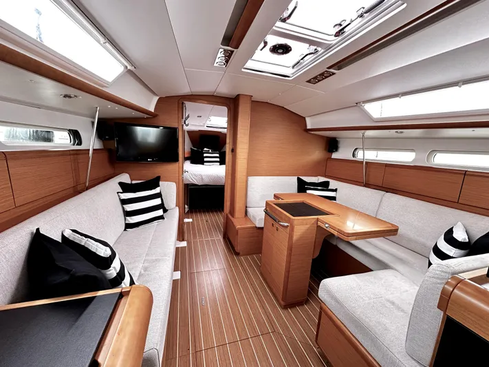  Yacht Photos Pics Luxurious interior of 2011 Jeanneau Sun Odyssey 409 sailboat with modern furnishings and striped cushions.