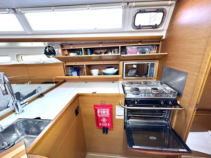  Yacht Photos Pics 2011 Jeanneau Sun Odyssey 409 yacht kitchen with stove, sink, and storage shelves.
