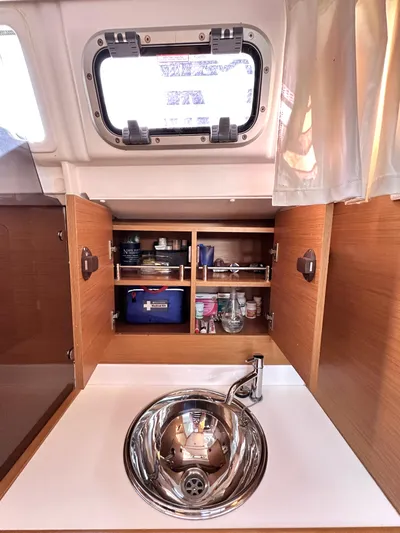  Yacht Photos Pics Interior of 2011 Jeanneau Sun Odyssey 409 yacht with sink and open storage cabinets.