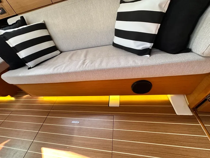  Yacht Photos Pics Interior of 2011 Jeanneau Sun Odyssey 409 with striped cushions and wooden flooring.