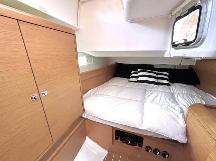  Yacht Photos Pics Cozy cabin interior of 2011 Jeanneau Sun Odyssey 409 with bed and wooden cabinetry.