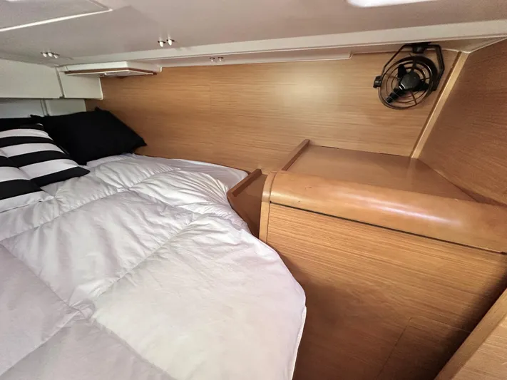 Yacht Photos Pics Cozy cabin interior of 2011 Jeanneau Sun Odyssey 409 with wood finish and bedding.