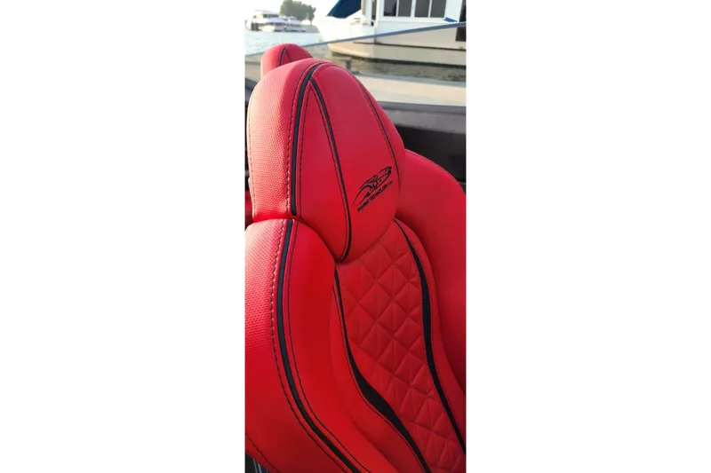  Yacht Photos Pics Red MTI 440X 2025 boat seat with diamond stitching and logo, docked by water.