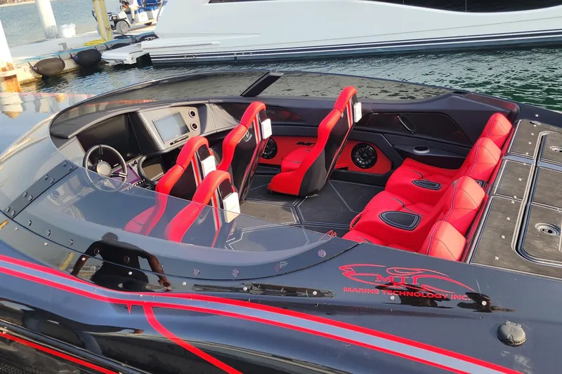  Yacht Photos Pics Luxury MTI 440X speedboat interior with red seats, 2025 model, docked by the water.