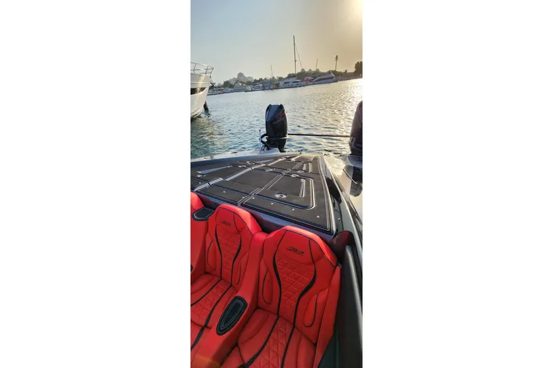  Yacht Photos Pics 2025 MTI 440X boat with red seats, docked in a serene marina at sunset.