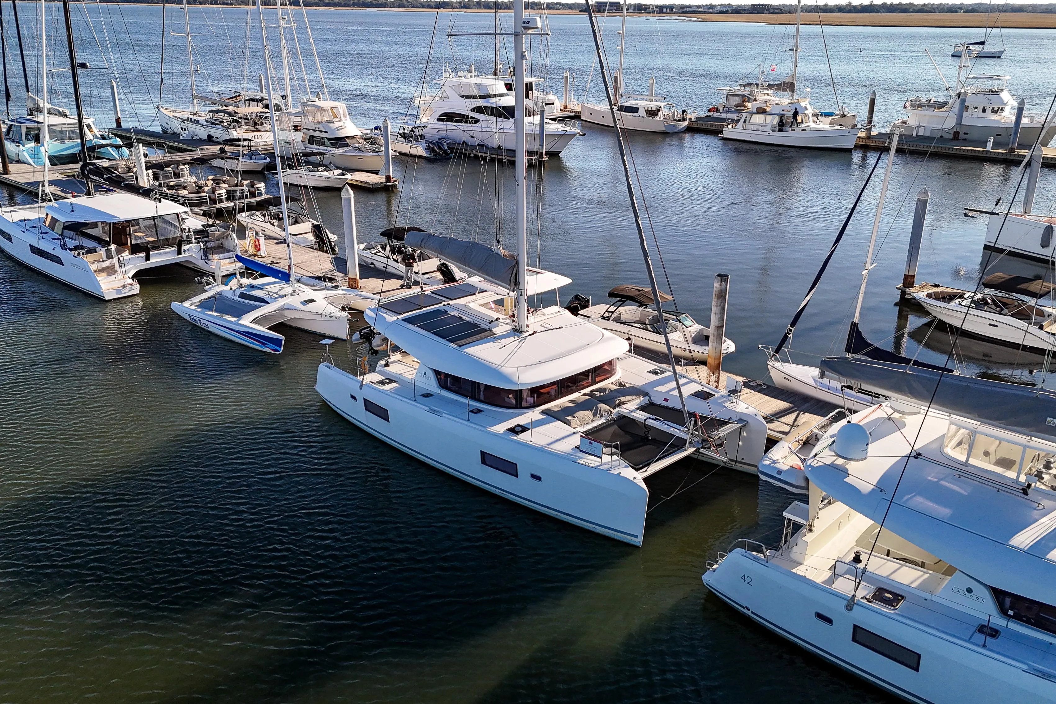 2017 Lagoon 42 Owners Version catamaran docked among other boats in a marina.