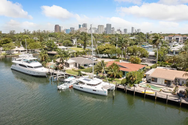 Curvy Mermaid Yacht Photos Pics Lagoon 42 catamaran docked in a scenic waterfront neighborhood with city skyline.