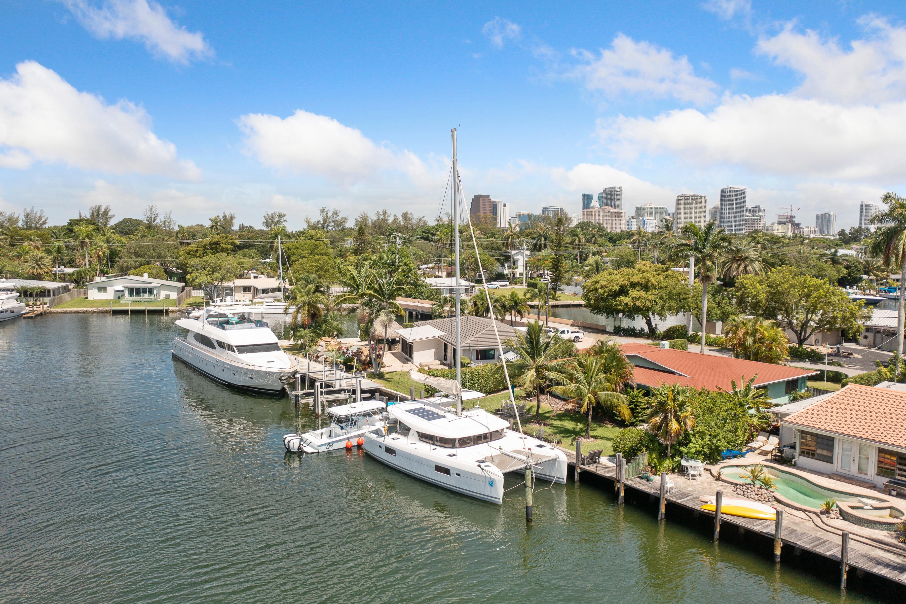 Lagoon 42 catamaran docked in a scenic marina with city skyline backdrop.