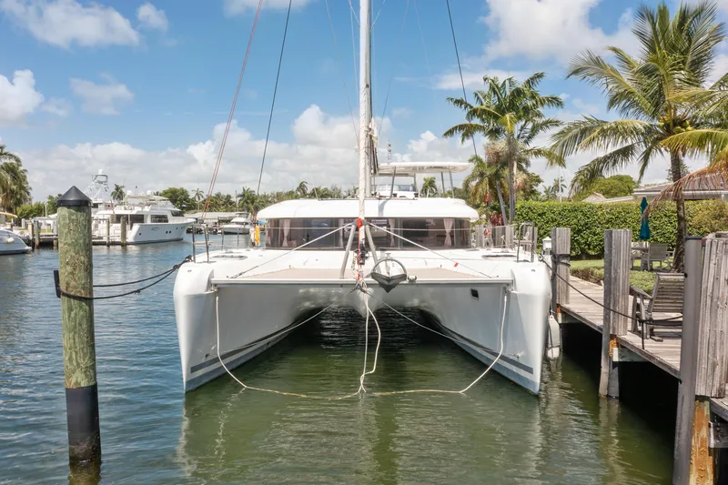 Curvy Mermaid Yacht Photos Pics 2017 Lagoon 42 catamaran docked at a marina with palm trees and clear skies.