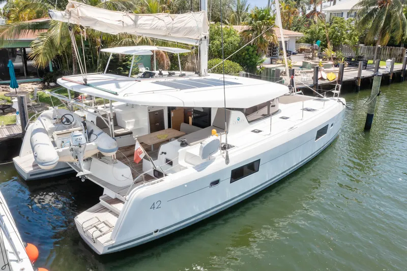 Curvy Mermaid Yacht Photos Pics 2017 Lagoon 42 catamaran docked in a tropical marina setting.