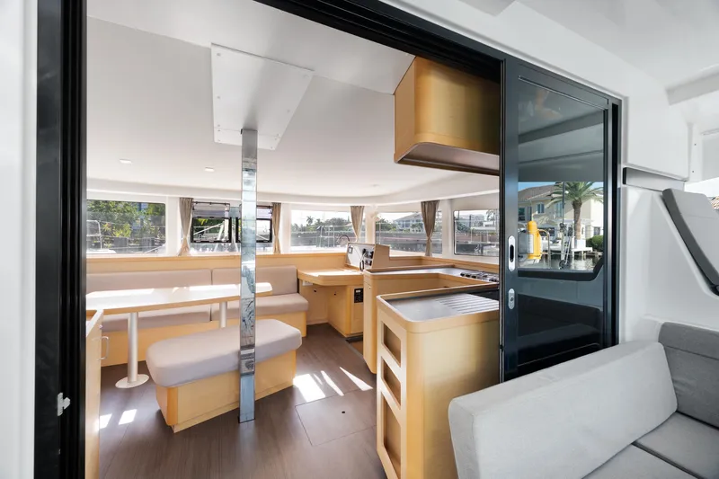 Curvy Mermaid Yacht Photos Pics Interior of 2017 Lagoon 42 catamaran, featuring modern kitchen and dining area with ample natural light.