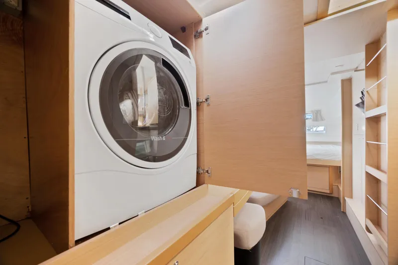Curvy Mermaid Yacht Photos Pics Washing machine inside 2017 Lagoon 42 catamaran, wooden interior, open cabinet door.