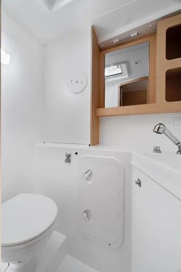 Curvy Mermaid Yacht Photos Pics Bathroom interior of a 2017 Lagoon 42 yacht, featuring a toilet, sink, and mirror.