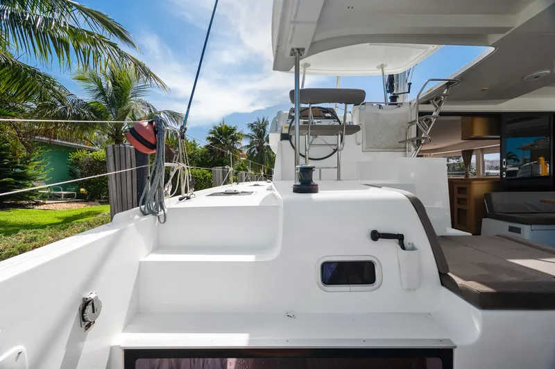 Curvy Mermaid Yacht Photos Pics 2017 Lagoon 42 catamaran deck with seating, tropical backdrop, and clear blue sky.