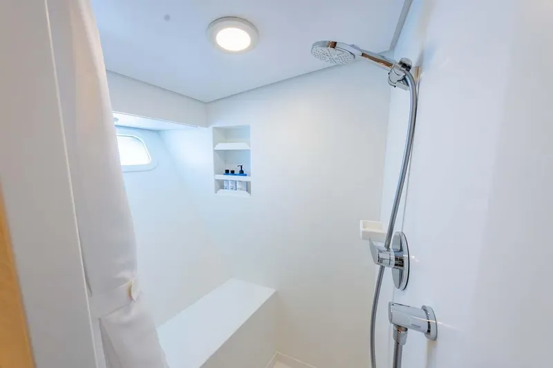 Catch Yacht Photos Pics Modern shower area in 1984 Feadship Yacht Fish, featuring sleek fixtures and built-in shelving.