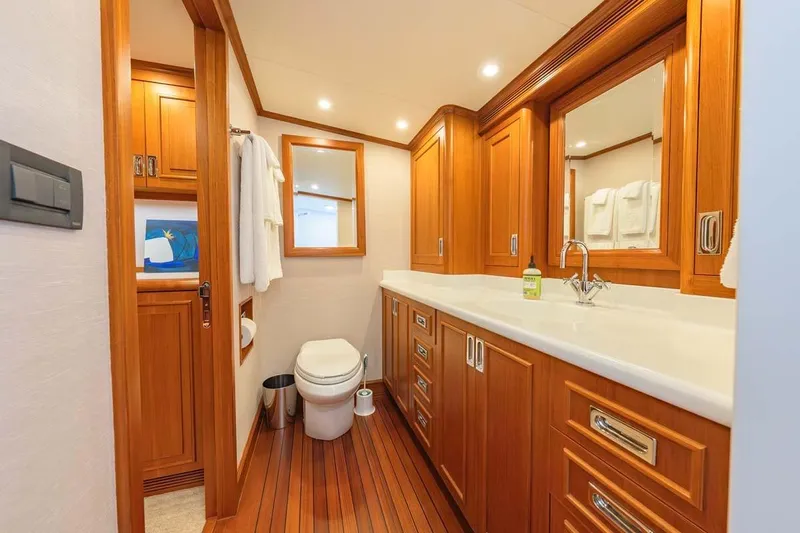 Catch Yacht Photos Pics Luxurious 1984 Feadship Yacht Fish bathroom with wooden cabinetry and modern fixtures.