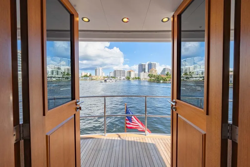Catch Yacht Photos Pics View from 1984 Feadship Yacht Fish, open doors, city skyline, and American flag.