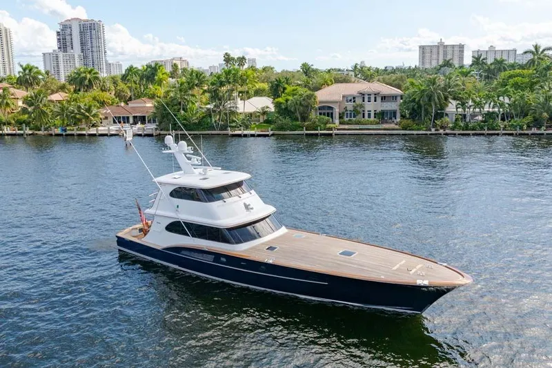 Catch Yacht Photos Pics 1984 Feadship Yacht Fish cruising on a scenic waterway with luxury homes in the background.