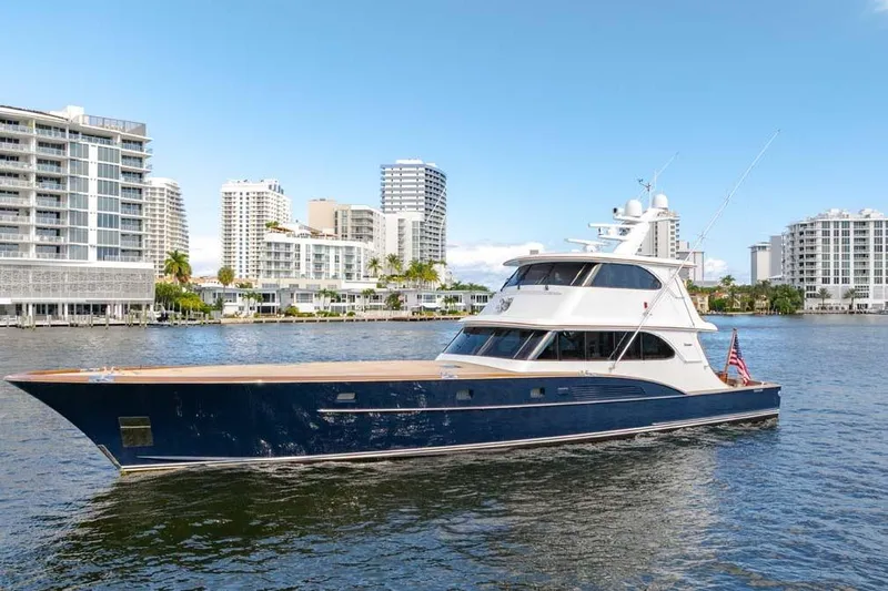 Catch Yacht Photos Pics 1984 Feadship Yacht Fish cruising near modern waterfront buildings.