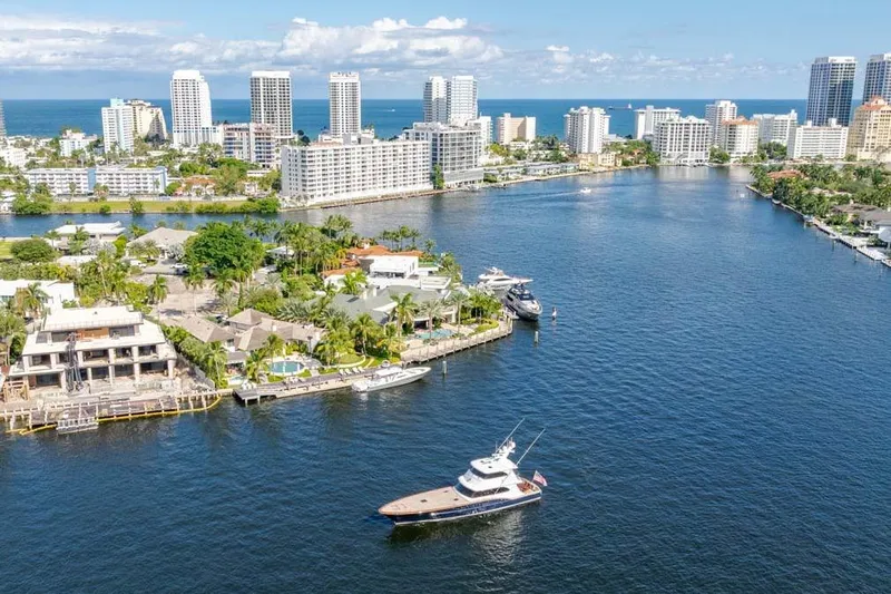Catch Yacht Photos Pics Aerial view of 1984 Feadship Yacht Fish cruising near coastal city skyline.