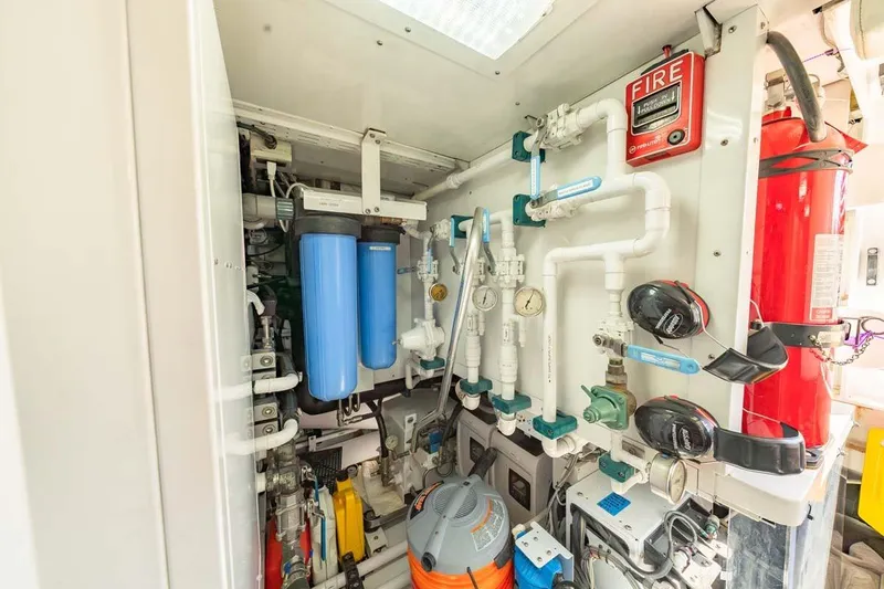 Catch Yacht Photos Pics Engine room of 1984 Feadship Yacht Fish, featuring pipes, gauges, and fire safety equipment.