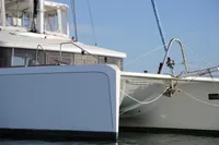 2013 Lagoon 52 F catamaran, white hull, docked on calm water.