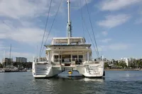 2013 Lagoon 52 F catamaran on water, marina in background, clear sky.