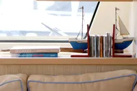 Interior of 2013 Lagoon 52 F yacht with model sailboats and books on a shelf.