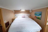 Luxurious cabin interior of 2013 Lagoon 52 F yacht with cozy bed and nautical decor.