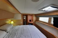 Luxurious cabin interior of 2013 Lagoon 52 F yacht with cozy bed and natural lighting.