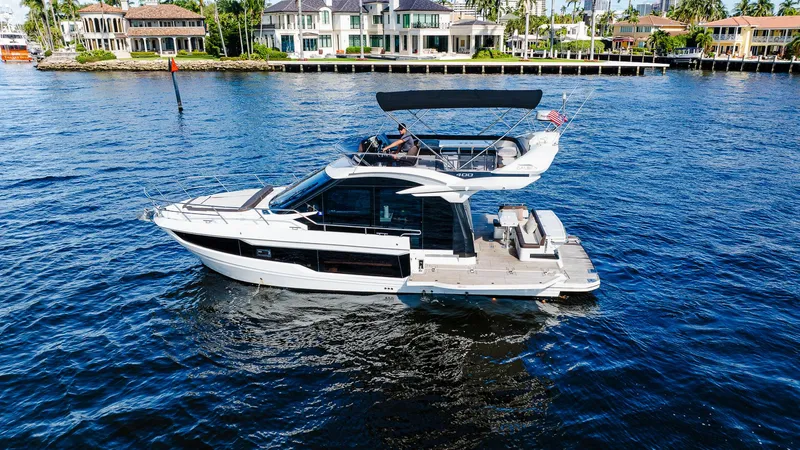 Lei Vola Yacht Photos Pics 2022 Galeon 400 Fly yacht cruising on a sunny waterfront.