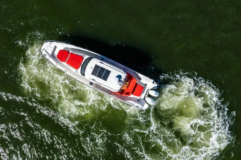  Yacht Photos Pics Aerial view of 2023 Nimbus Tender 11 boat cruising on green water.